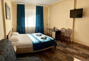 沃罗涅什Hotel Nord的酒店客房带一张床、一张桌子和椅子