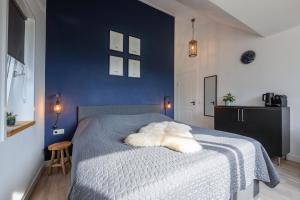 德科克斯多普DOCK10TEXEL的蓝色卧室配有一张带白色毯子的床