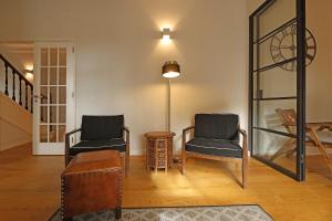波尔图FLH Seaside Luxury House in Porto的客厅配有两把椅子和一张桌子