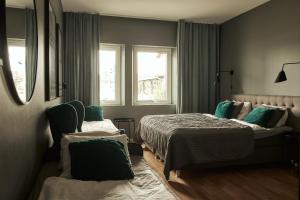 延雪平Hasse på Sjökanten Hotell & Restaurang的一间卧室设有两张床和两个窗户。