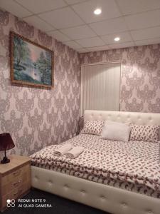 基辅DESYATINNAYA Hostel的卧室配有一张白色床,墙上挂着一幅画