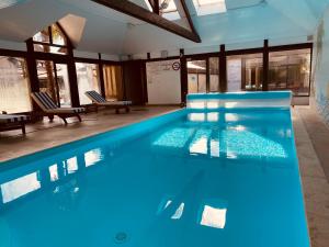圣加蒂安代布瓦Logis Le Clos Deauville Saint Gatien的大楼内的一个蓝色海水游泳池