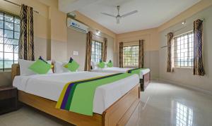 库斯哈尔纳加尔Treebo Trend Green Land Kushalnagar的大型客房设有2张床和窗户。