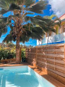 Grande AnseHotel Oasis的围栏旁的棕榈树游泳池