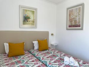 维拉摩拉Mouraliz Apartments by HD PROPERTIES - Vilamoura Marina的一间卧室配有带2个枕头和2张照片的床