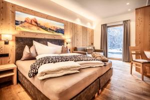 塞尔瓦迪加尔代纳山谷Luxury Chalet Plazola的一间卧室设有一张大床和一个大窗户
