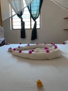 江比阿Kasuku Villa的床上有枕头,上面有粉红色的花朵