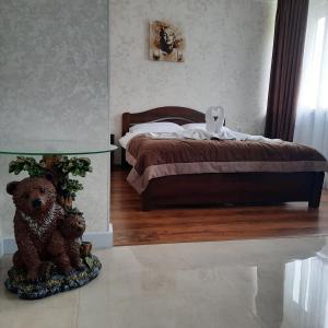 ZwiahlГотельно-ресторанний комплекс «Тополя»的一间卧室配有一张带泰迪熊和桌子的床