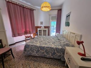莱圭利亚Villa Pina的一间卧室配有一张床、一张桌子和一盏灯