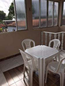 索雷Apartamento Suíte em Soure.的窗户客房内的白色桌椅