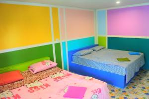 柴老海滩部恩南华度假酒店的色彩缤纷的客房内的两张床