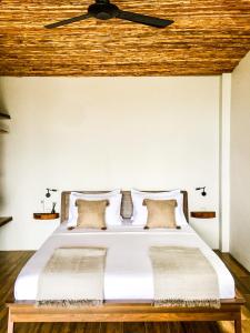 哈德姚Mayara pool villas的卧室配有白色床和木制天花板
