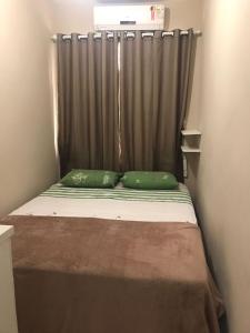 里约热内卢!Penha casa toda mobiliada para temporada的一张带两个绿色枕头的床