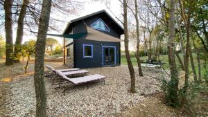 博尼约Domaine Vallon des Ocres的树林中间的蓝色小房子