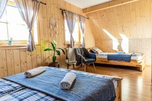 恰萨纳格拉Farmerska Chata的配有木墙和窗户的客房内的两张床