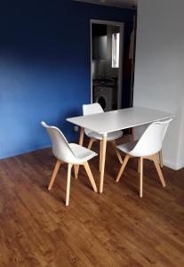 多维尔Résidence le Manoir du Mont Canisy Piscine & Tennis的客房内的一张白色桌子和两把白色椅子