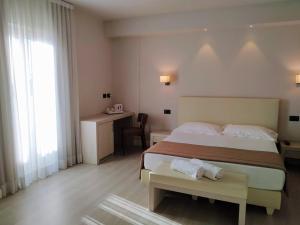 马里纳-迪-皮特拉桑塔Hotel Villa Barsanti的配有一张床、一张桌子和一张桌子的酒店客房