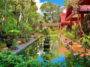 华欣卢恩卡诺克泰屋度假酒店的房屋前带池塘的花园