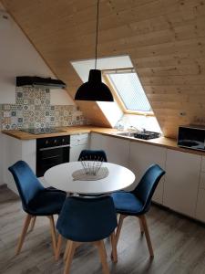 TruchtersheimSuperbe appartement type T1 proche Strasbourg的厨房配有白色的桌子和蓝色的椅子