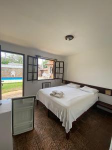 布希奥斯Calmaria Búzios的卧室设有一张白色大床和一扇窗户。