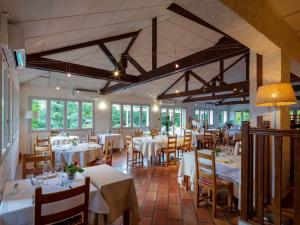 维列莫尔贡Logis Noemys Morgon的餐厅设有白色的桌椅和窗户。
