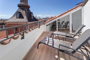 马德里B&B HOTEL Madrid Centro Plaza Mayor的阳台配有两把椅子和屋顶