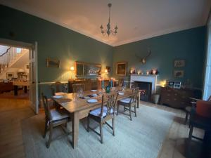 ChillinghamChillingham Manor的一间带桌椅和壁炉的用餐室