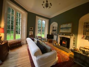 ChillinghamChillingham Manor的客厅配有白色沙发和壁炉