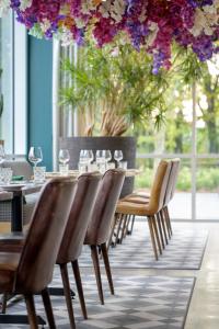 迭戈姆布鲁塞尔机场假日酒店的一间带桌椅和鲜花的用餐室