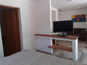 查克拉斯德科里亚Pequeña casa en chacras de coria的一间卧室配有一张桌子,上面有一台电脑显示器