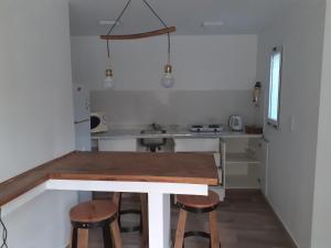 查克拉斯德科里亚Pequeña casa en chacras de coria的一个带木桌和凳子的小厨房