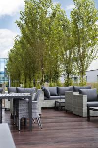 卢斯特瑙Holiday Inn Express - Lustenau的天井配有沙发、桌子和树木