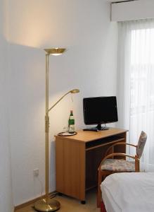 巴特嫩多夫Hotel Deisterblick的一间卧室配有一张桌子、一台电脑和一盏灯
