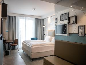 德累斯顿Hotel Indigo Dresden - Wettiner Platz, an IHG Hotel的配有一张床和一张书桌的酒店客房