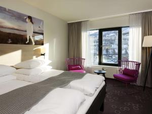 纳尔维克纳尔维克斯堪迪克酒店的酒店客房带两张床和两张粉红色椅子