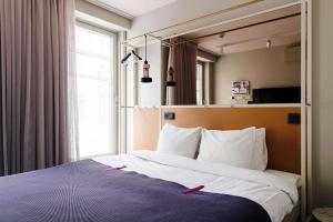 斯德哥尔摩斯堪第53号酒店的一间卧室设有一张大床和大窗户