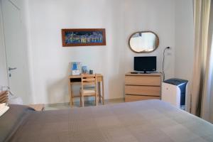 圣玛格丽塔-利古雷Sunrise Apartment的一间卧室配有一张床、一张桌子和一面镜子