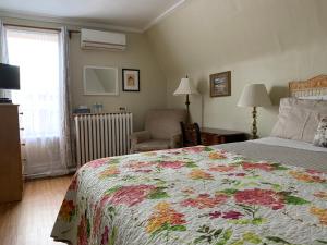 渥太华丽都旅馆的一间卧室配有一张带花卉床罩的大床