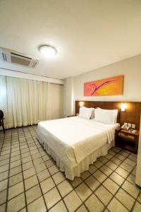 福塔莱萨普拉亚塞罗酒店的卧室配有一张白色大床