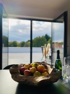 纳尔巴赫Ferienwohnungen Nalbach Bierbach的桌上的木苹果和一瓶葡萄酒