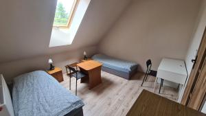 GolędzinówW20 Hostel的客房设有两张床、一张桌子和一张书桌。