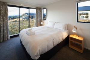 特卡波湖Loudon Lodge - Lake Tekapo的一间卧室设有一张大床和大窗户