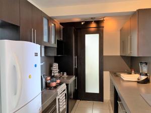 圣萨尔瓦多Luxury Modrn Apartment, w/amazing view, 3BR,Escalon,Exclus,Secur的厨房配有白色冰箱和黑色门