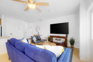 南帕诸岛Star Beach Side Condominiums #105的客厅配有蓝色沙发,设有吊扇