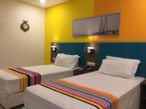 海得拉巴Hotel White Fields Hitec City, Hyderabad的配有两张床铺的客房,墙上配有电视