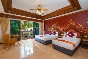 卡伦海滩Memory Karon Resort的一间卧室配有两张床和一张桌子及椅子