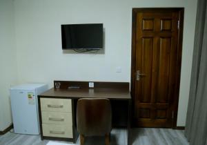 布哈拉Grand Ark Bukhara的一张桌子、椅子和墙上的电视
