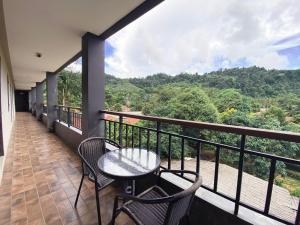 蔻立Rakkawan Residence - SHA EXTRA PLUS的设有一个配有桌椅并享有美景的阳台。