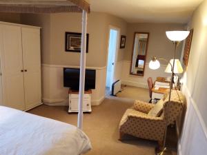 沃特牛顿西斯本酒店的一间卧室配有一张床、一张书桌和一台电视