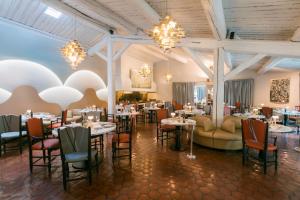 莱蓬特奥贝奇温泉酒店的用餐室配有桌椅和吊灯。